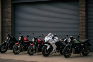 異なるスタイルのごつい大型バイク5台がガレージ前に整然と並んでいる様子